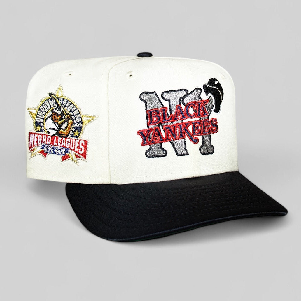 A black and white New York Black Yankees cap with a navy visor, featuring embroidered team logos.